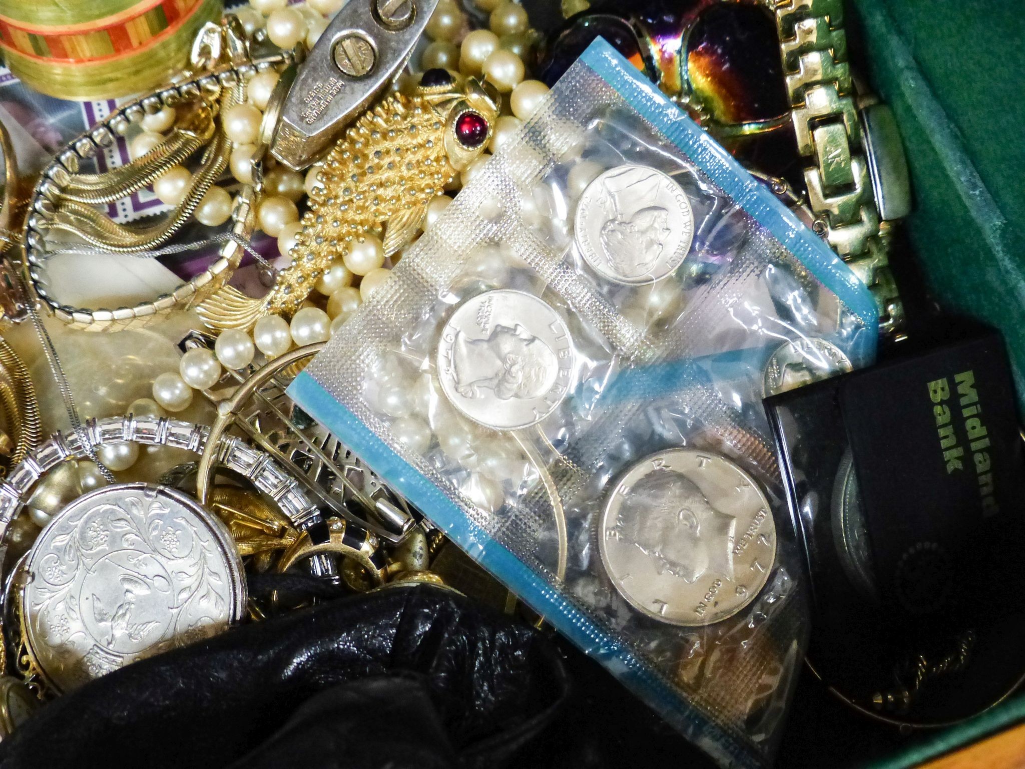 A quantity of assorted costume jewellery and coins etc. in a walnut box.